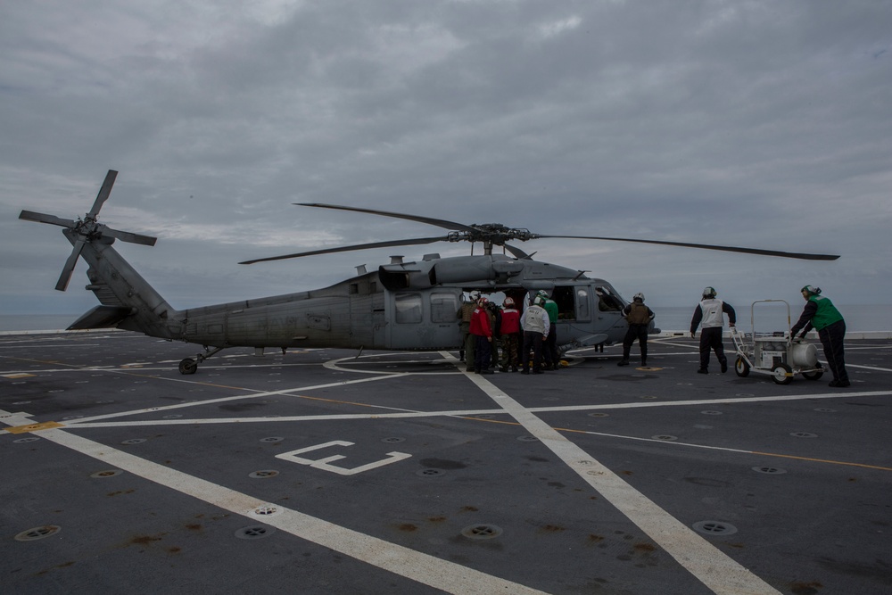 US Navy sailors with USS Arlington conduct maintenance on CH-60