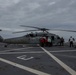 US Navy sailors with USS Arlington conduct maintenance on CH-60