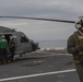 US Navy sailors with USS Arlington conduct maintenance on CH-60