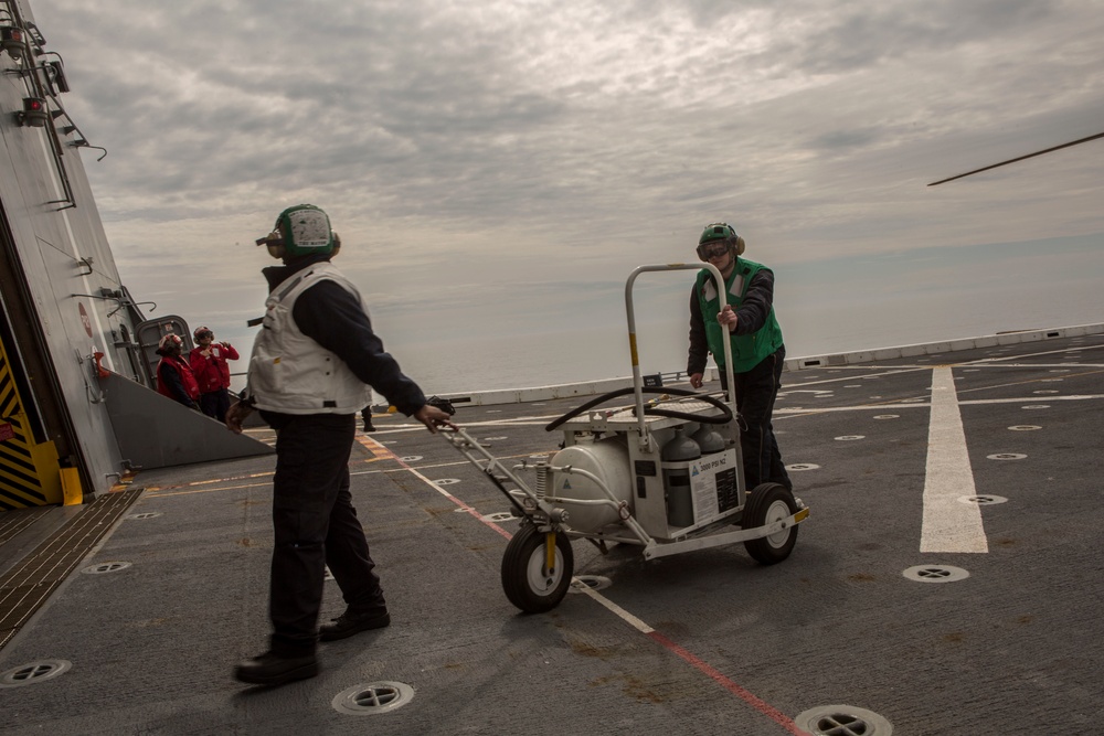 US Navy sailors with USS Arlington conduct maintenance on CH-60