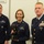 Coast Guard Sector Buffalo awards 2014 REPOY Three U.S. Coast Guard personnel are posing for a formal photo in what appears to be a planning room or briefing area. The central figure, a female service member, is holding a trophy or award featuring what appears to be a bronze eagle or bison figurine on a black base. The officer on the right is in a formal dress uniform with an extensive array of service ribbons and medals.