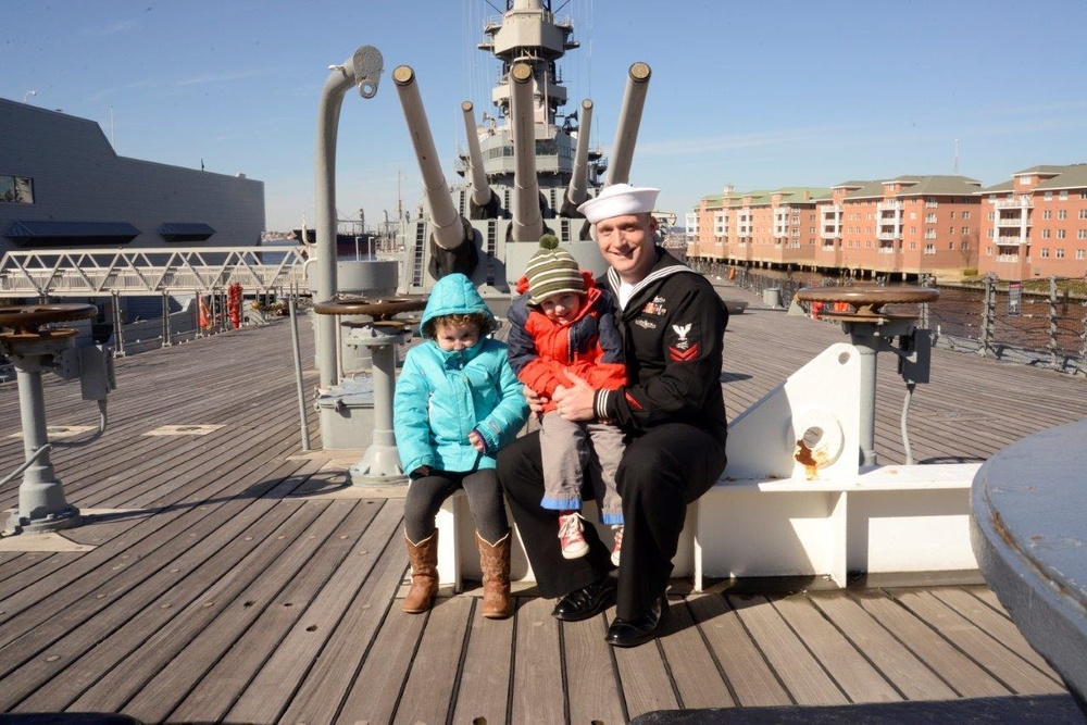 Sailor poses for photo aboard battleship USS Wisconsin