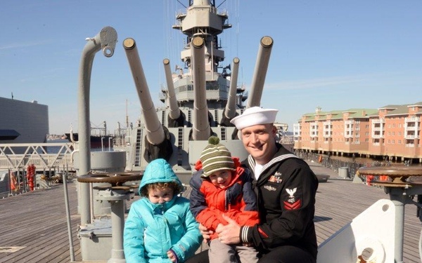 Sailor poses for photo aboard battleship USS Wisconsin