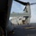 Osprey makes first ever landing on Republic of Korea amphibious assault ship The image shows a V-22 Osprey tiltrotor aircraft on the flight deck of a naval amphibious assault ship, viewed from the rear ramp perspective. Military personnel in camouflage uniforms are visible boarding or near the aircraft, while deck crew in yellow safety vests are visible on the flight deck in the background. The ship's superstructure and open ocean are visible in the background.