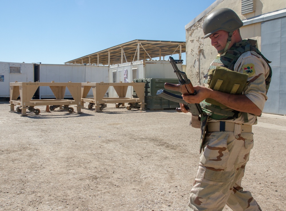 Iraqi soldier examines his rifle