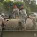Soldiers and airmen clean vibratory roller