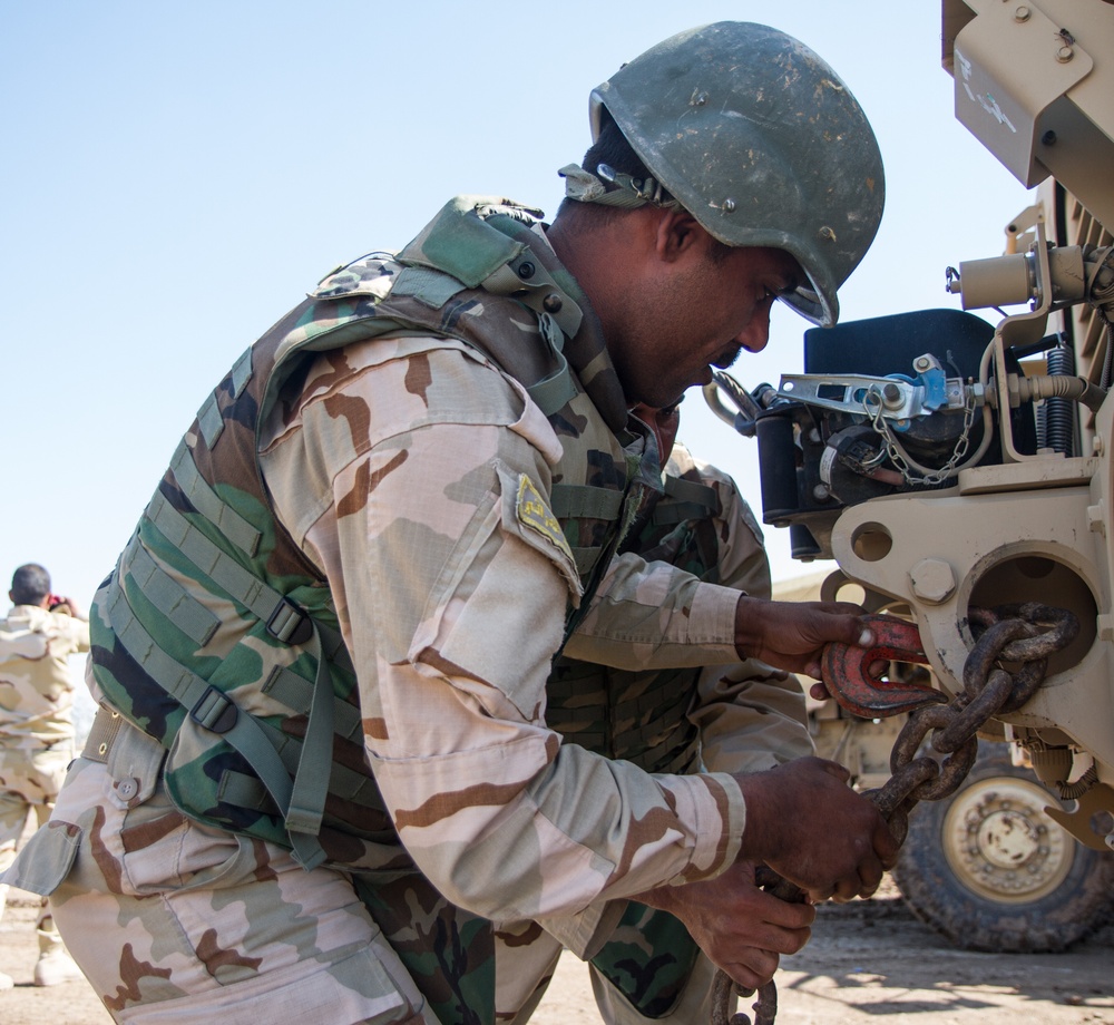 Iraqi soldier prepares MRAP for tow