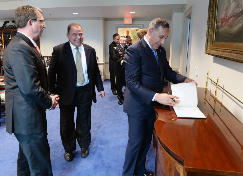 Secretary of Defense Ash Carter stands next to Haider al-Abadi Prime Minister of Iraq signing the guest book