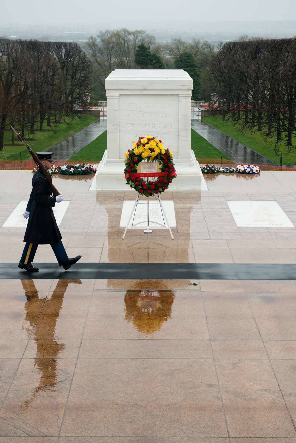 Tomb sentinel walk past wreath in Arlington National Cemetery