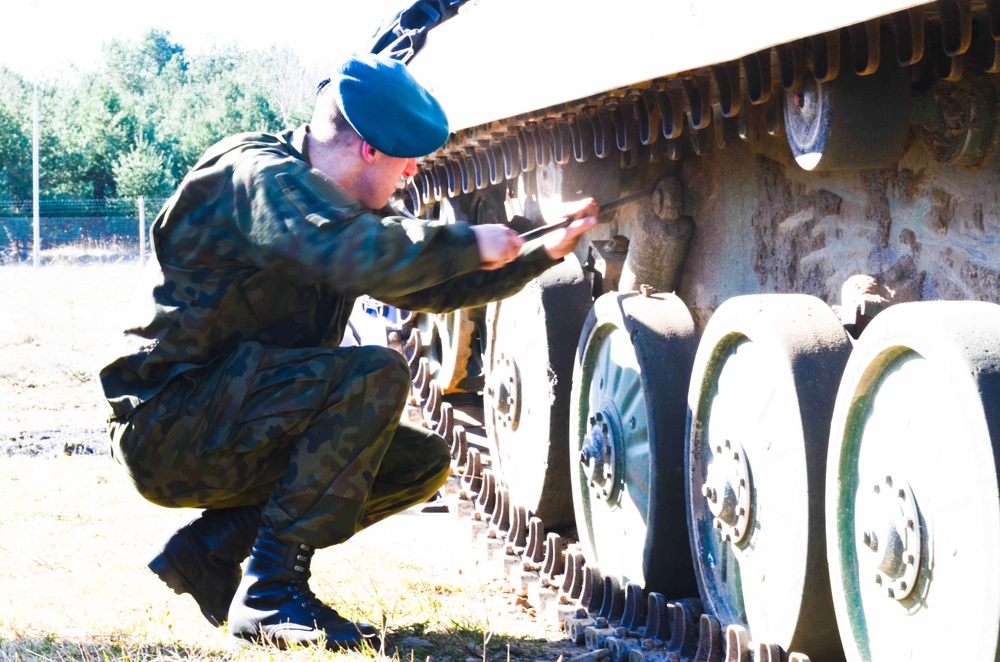 A Polish soldier conducts vehicle maintenance at Camp Konotop, Poland.