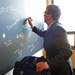 Secretary of Defense Ash Carter autographs the Stanford Board before speaking at the Drell Lecture