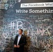 Secretary of Defense Ash Carter stands in front of the Facebook Wall during his recent trip to their headquarters