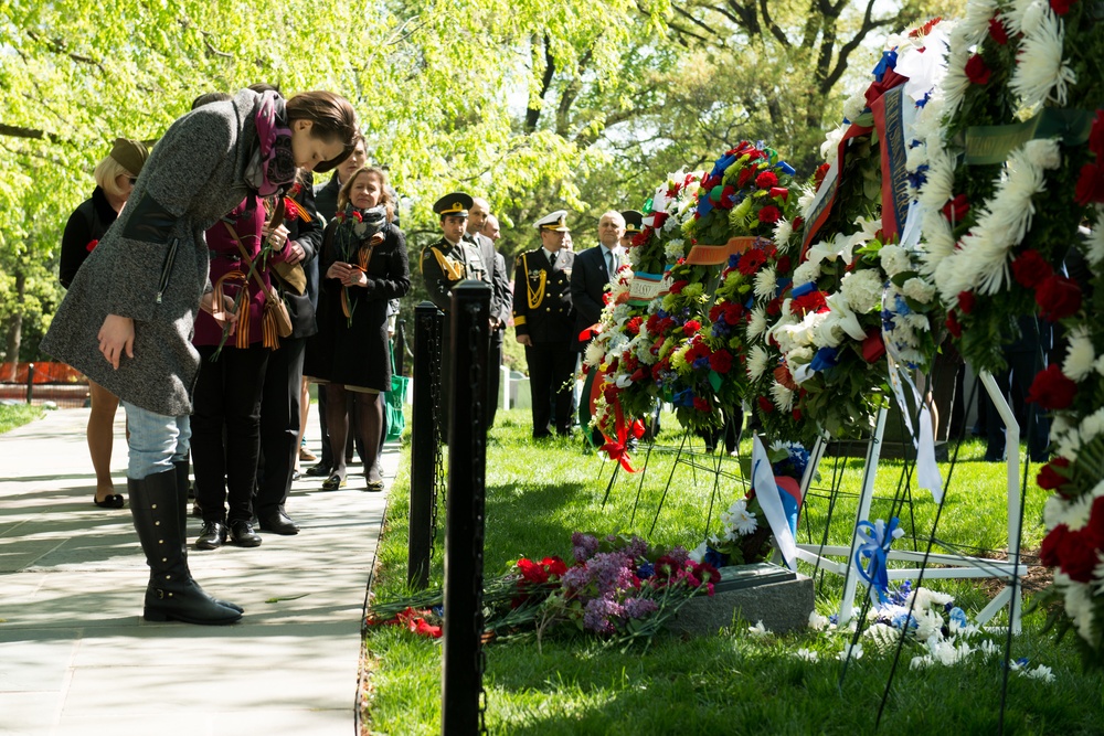 Attendees lay flowers on The Spirit of the Elbe marker in Arlington National Cemetery
