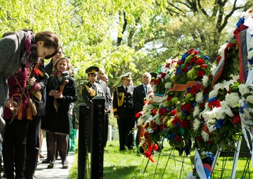 Attendees lay flowers on The Spirit of the Elbe marker in Arlington National Cemetery