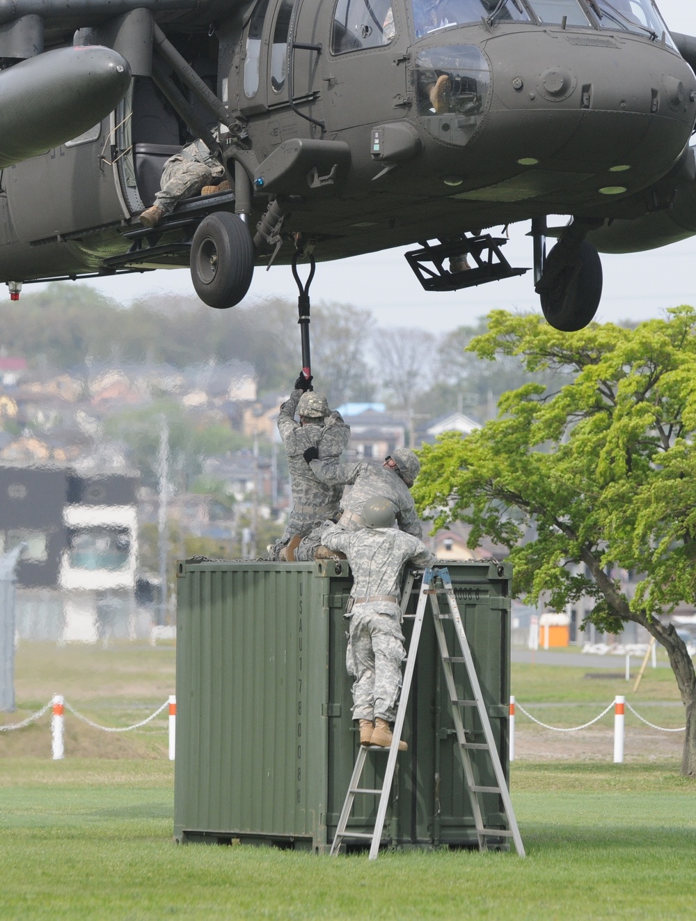 Soldiers from 35th CSSB connect a cable to a UH-60 helicopter