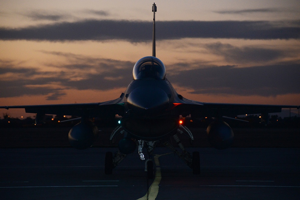 F-16 taxis on runway at night