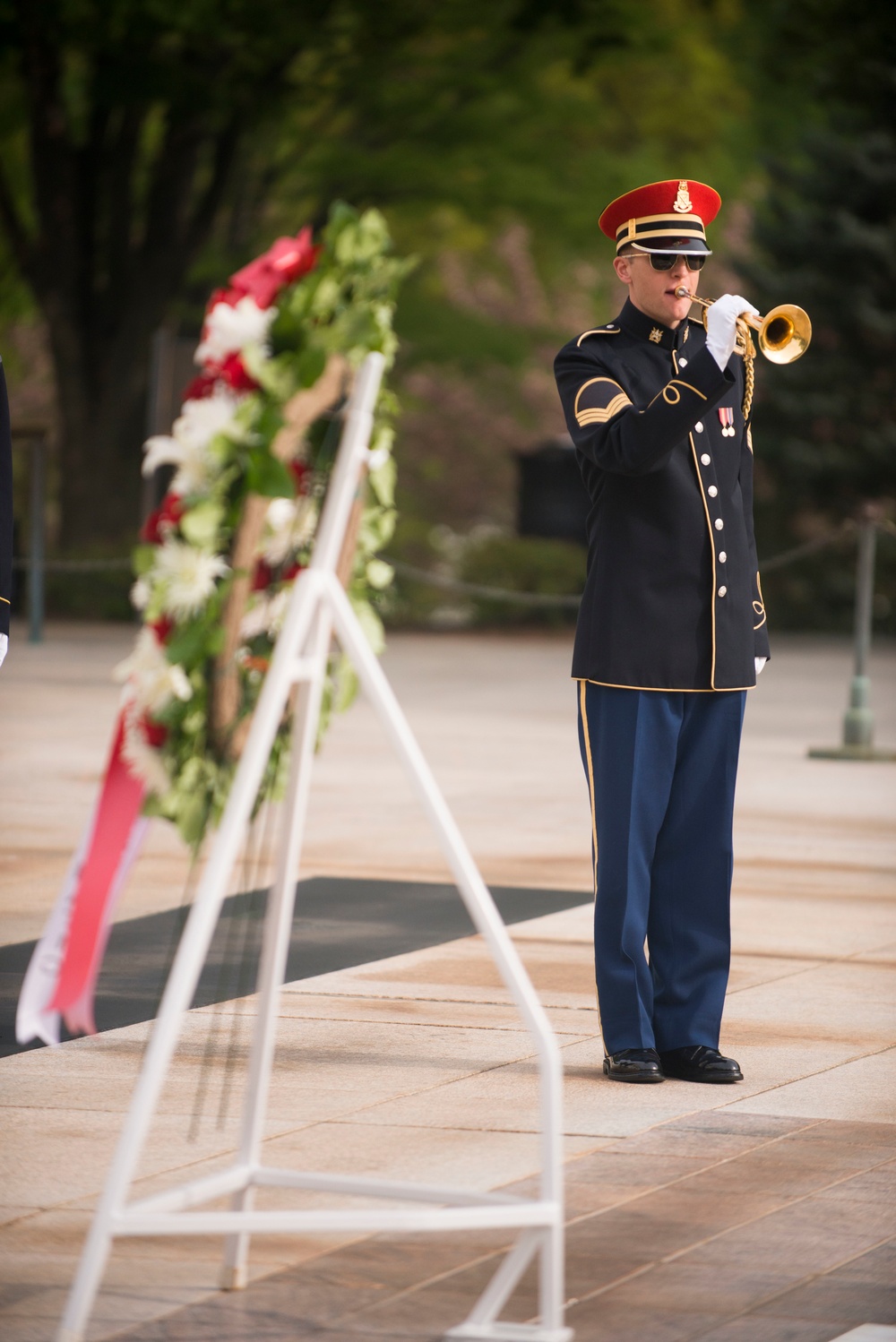 A bugler from The US Army Band 'Pershing’s Own' plays Taps during a wreath-laying ceremony at the Tomb of the Unknown Soldier, Arlington National Cemetery