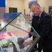 Republic of Croatia minister of veterans affairs places a gift into a display case in Memorial Display Room, Arlington National Cemetery