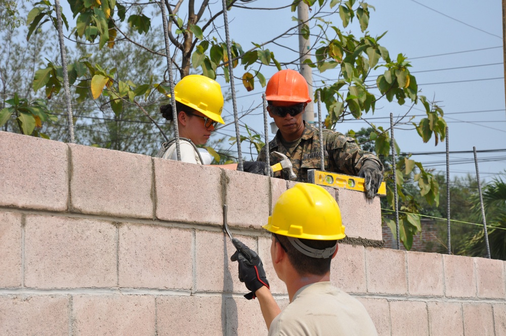 Soldiers of different trades pitch in to lay block