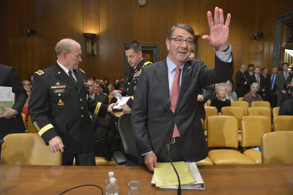 Secretary of Defense Ash Carter waves to members of the committee as he and Chairman of the Joint Chiefs of Staff Army Gen. Martin Dempsey prepare to testify before the Senate Appropriations Committee