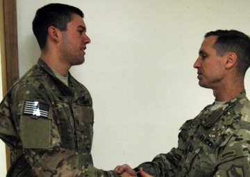 Spc. Shannon Gainey receives a coin