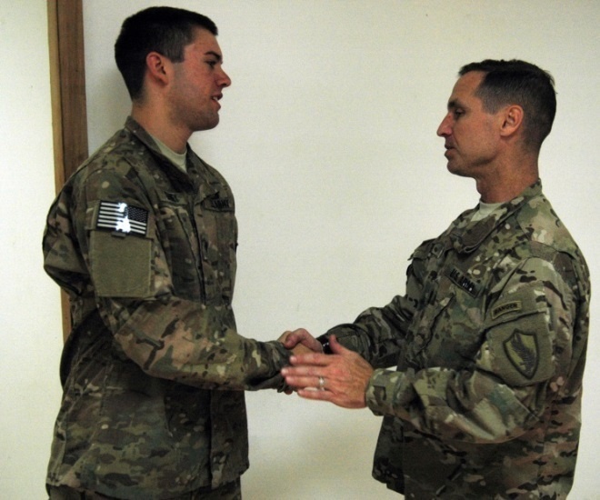 Spc. Shannon Gainey receives a coin