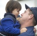 A US Coast Guard Bertholf crew member embraces his son after returning to homeport