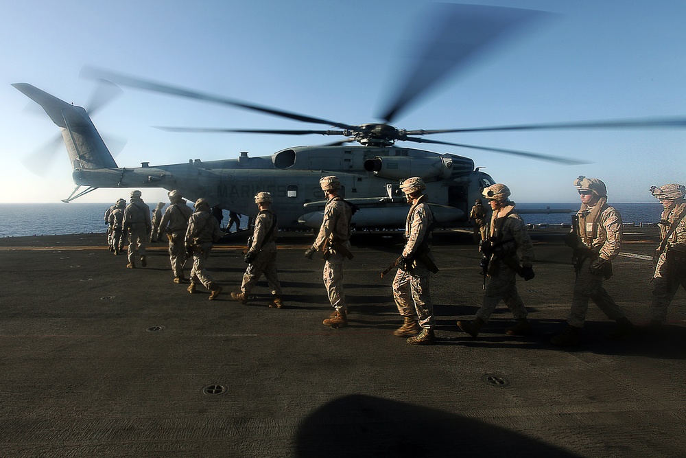 US Marines fast rope from helicopters at sea