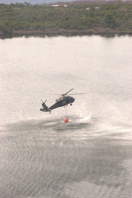 Army National Guard helicopter crews conduct water bucket training over Round Lake  this afternoon, May 28