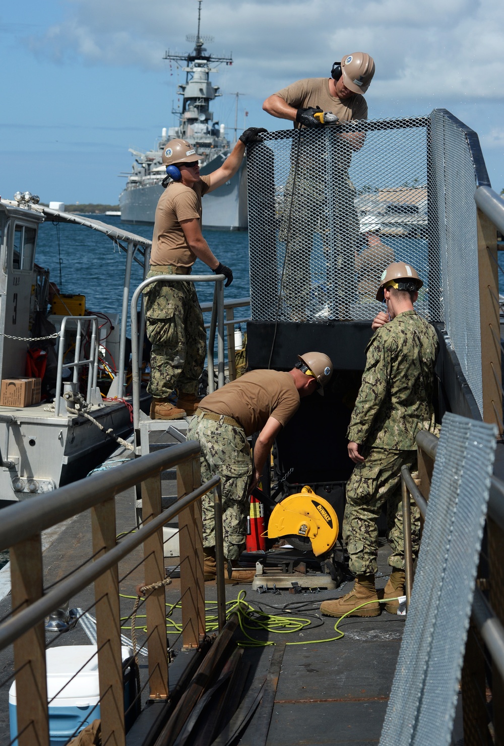 Sailors work to repair the floating dock next to the USS Arizona Memorial