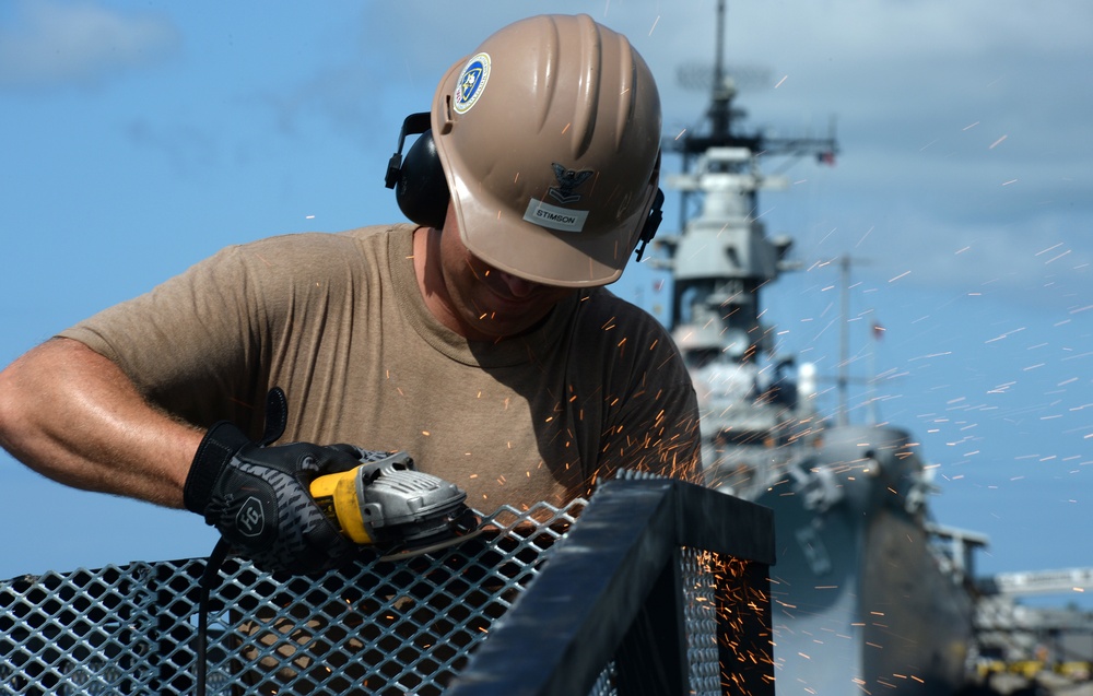 Sailors work to repair the floating dock next to the USS Arizona Memorial