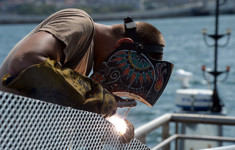 Sailor works to repair the floating dock next to the USS Arizona Memorial