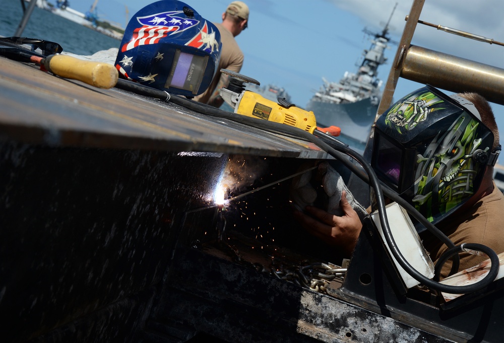 Sailors work to repair the floating dock next to the USS Arizona Memorial