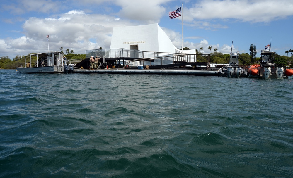 Sailors work to repair the floating dock next to the USS Arizona Memorial