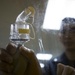 Multi-national military medical personnel conduct M95 respirator fit testing aboard USNS Mercy