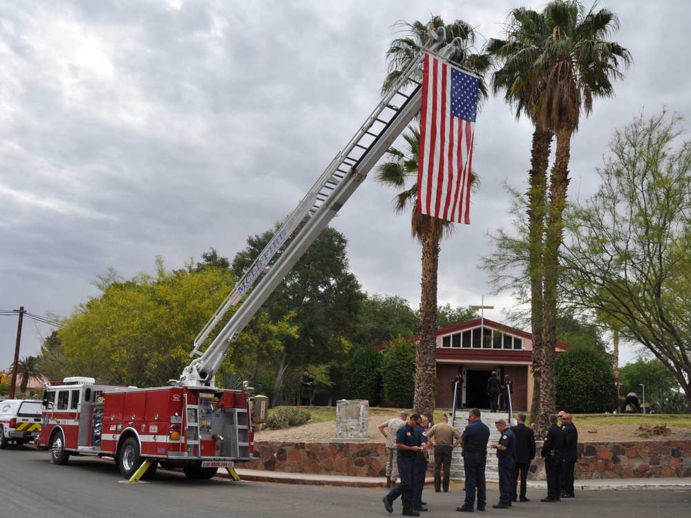 Marines, police and fire personnel fly an American flag in mourning the loss of Lt. Levi Baker