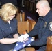 MCPD officer Kyle Fraser hands flag to Jennifer Denton in memory of Lt. Levi Baker