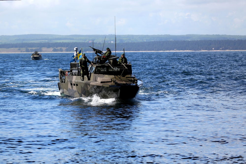 Armored vehicles loaded with troops hit the beach in Sweeden during BALTOPS 2015