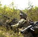 Strapped with firepower: A U.S. Marine waits in the bushes to engage enemy forces in Lithuanian Pabrade Training Area