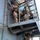 Maritime Raid Force, 26th MEU conducts VBSS training The image shows a group of armed military or special operations personnel conducting what appears to be a maritime boarding operation on the exterior of a naval vessel. Personnel are ascending external staircases and ladders on the ship's superstructure, wearing full tactical gear including helmets, body armor, and carrying weapons. The operation appears to be either a live exercise or training drill based on the coordinated movement of multiple operators.