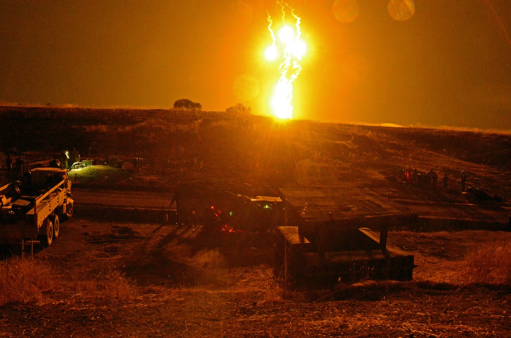 Illumination rounds shot from mortar ignite the midnight sky