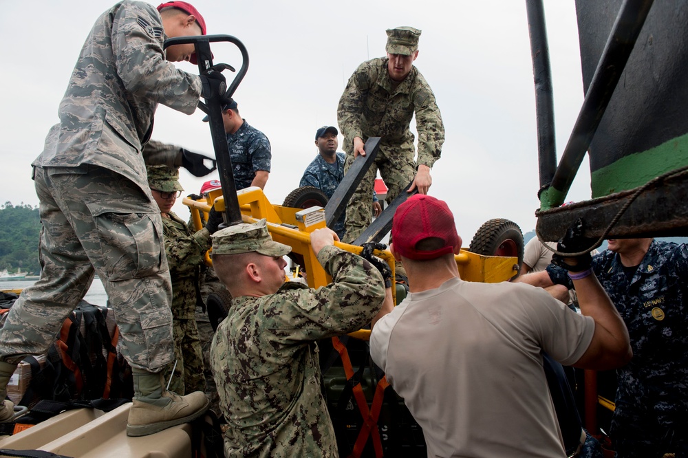 Navy Seabees and Air Force RED HORSE engineers unload a ship during Pacific Partnership