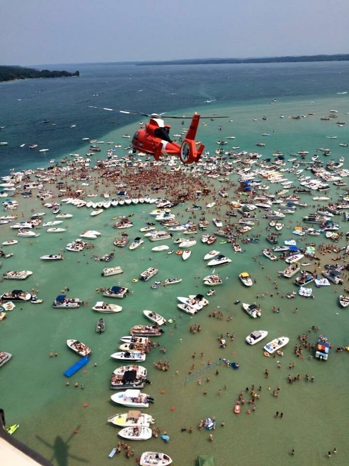 Air Station Traverse City helicopter flies over Torch Lake sandbar party