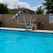 Mirian Hemme, a military spouse and volunteer in the Public Affairs Office, demonstrates her tumbling skills off the diving board at Oasis Pool and Water Park during the All American BBQ aboard Marine Corps Logistics Base Barstow, Calif., July 4