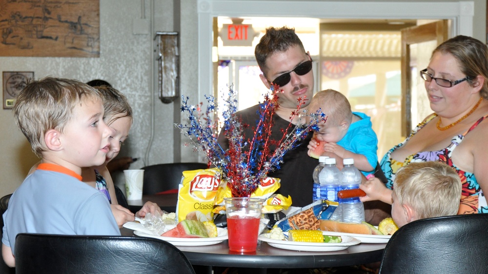 Sgt. Evan T. Schoenwald, platoon sergeant, his wife Kimber and their children, Maggie, nine years old, four year old Wyatt, Landen age two, and nine month old Sophia, enjoy food and games during the All American BBQ held at the Oasis Pool and Water Park