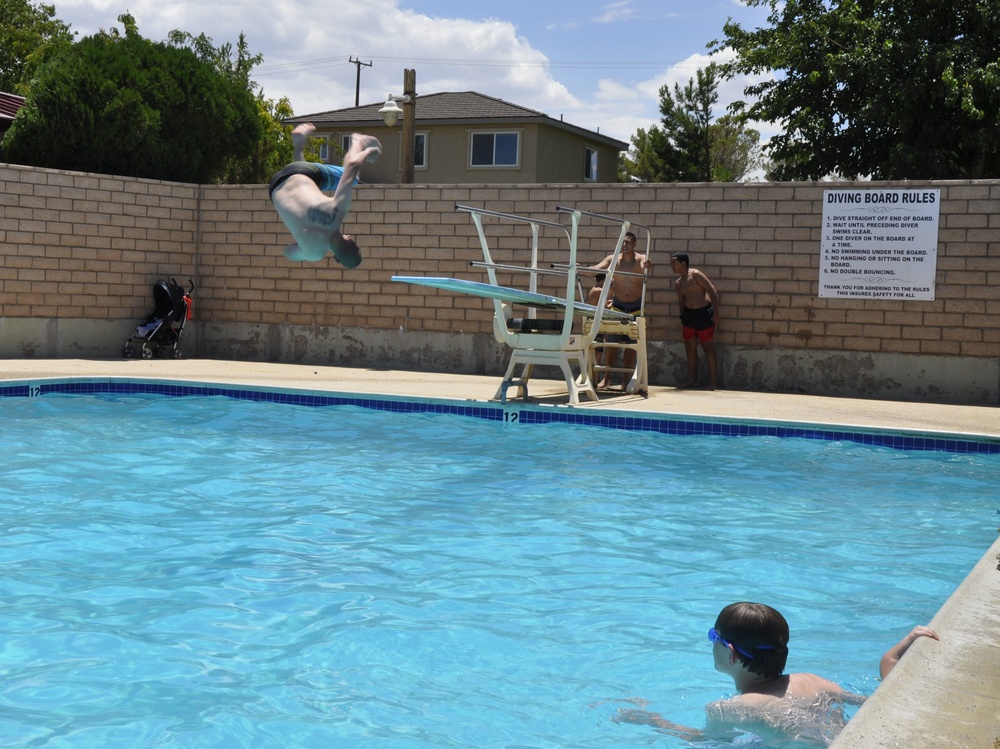 Staff Sgt. James Hainer Jr., cyber network systems chief, joins the dive-off during the All American BBQ at the Oasis Pool and Water Park aboard Marine Corps Logistics Base Barstow, Calif., July 4