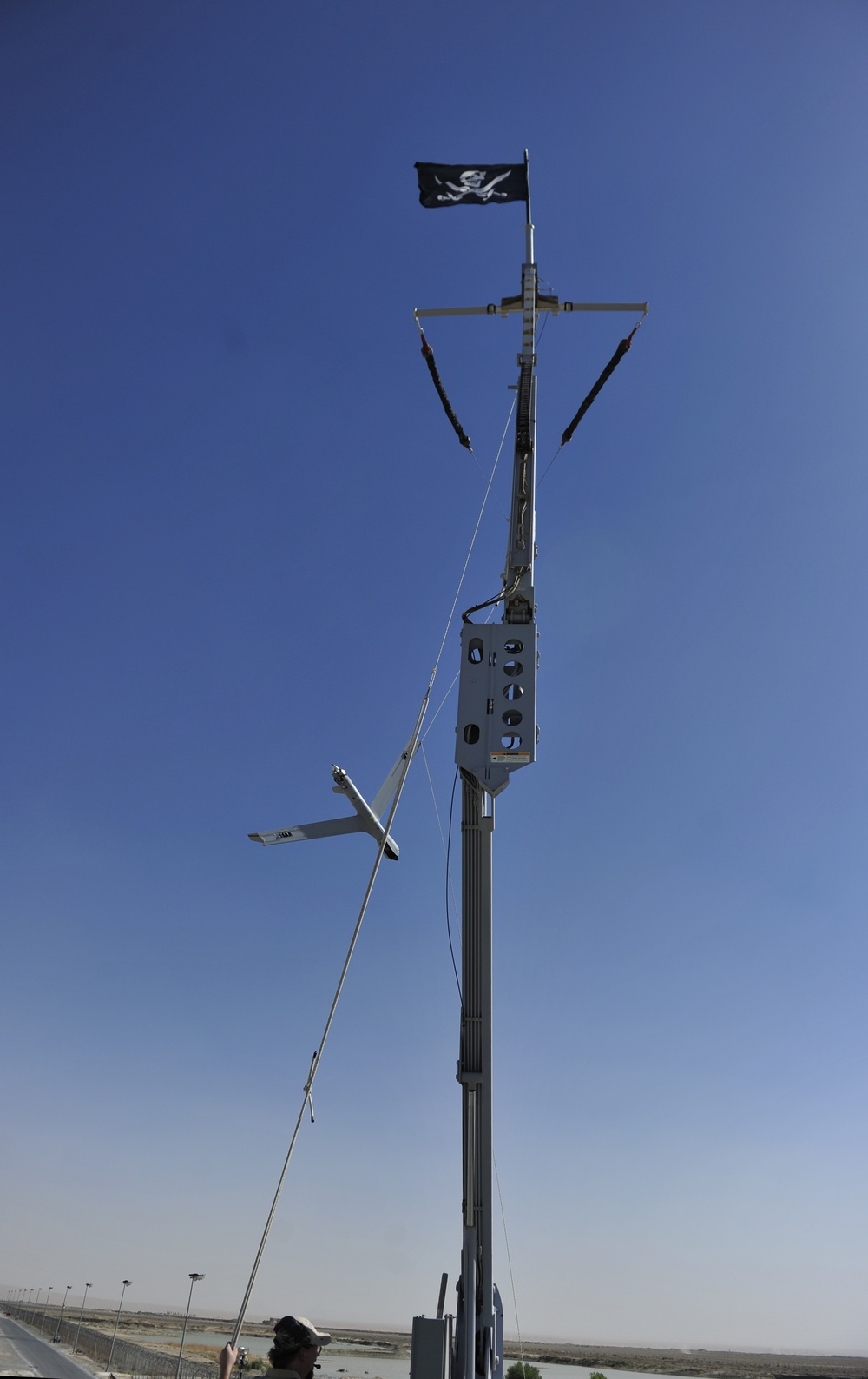 ScanEagle unmanned aerial vehicle hangs from the vertical cable after being recovered by the Skyhook system at Kandahar Airfield June 25, 2015