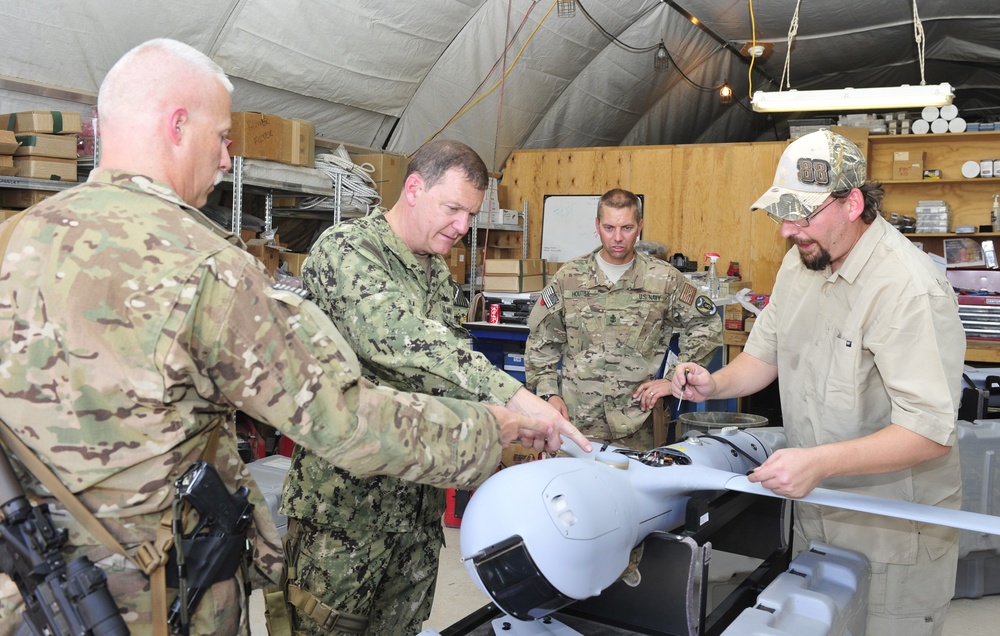 US Navy Rear Adm. Luke McCollum, vice commander, US Naval Forces Central Command, examines ScanEagle avionics system at Kandahar Airfield June 25, 2015
