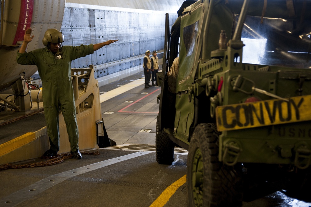 U.S. Sailor directs equipment and cargo onto a landing craft air cushion vehicle during Talisman Sabre 2015