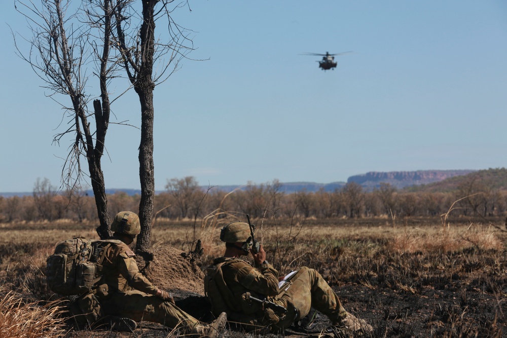 Australian soldiers and U.S. Marines air assault through a mock enemy objective